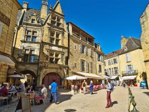 萨尔拉拉卡内达Pause Dordogne Ambiance Cozy à Sarlat的一群人走在街道上,有建筑