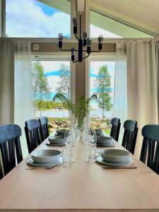 RobertsforsStuga med havsutsikt的餐桌、椅子和大窗户