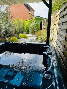 布赖迪讷Spa privatif à Bray-Dunes的院子里的黑色浴缸,有水