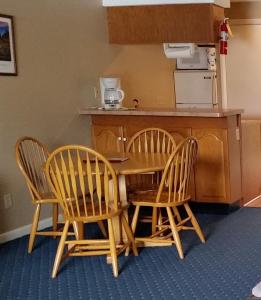 沃尔夫伯勒Windrifter Resort的厨房配有三把椅子、一张桌子和一个柜台