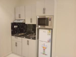 利雅德فندق دره الراشد للشقق المخدومه的厨房配有冰箱和微波炉。