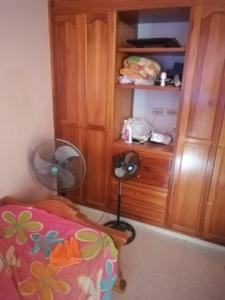 里考尔特Casa de Descanso的一间带风扇的卧室,毗邻一个木制橱柜