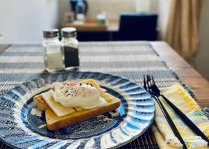 莫斯塔Free Breakfast, Pool, Spacious Aircon Hideaway的蓝白的盘子,上面有一块面包和奶油
