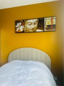 布赖迪讷Spa privatif à Bray-Dunes的一张带黄色墙和面具照片的床