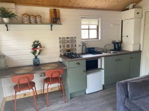 莱特肯尼Letterkenny Cabin的一间厨房,里面设有两张凳子和一个柜台