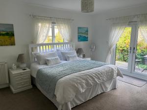 巴特尔Lissett Lodge的卧室配有白色的床铺、白色的床单和窗户。