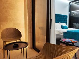 布德瓦Lolo Luxury rooms & suites的一间带椅子的房间和一间带床的卧室