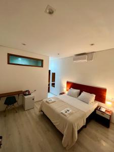 圣保罗Bistu Hotel - Vila Nova Conceição的一间卧室配有一张大床和一张书桌