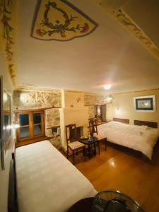 阿尔奈阿Aristotelous Alexandrou Historic Inn的一间卧室设有两张床和石墙