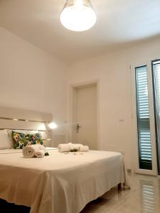 卡斯特里尼亚诺德尔卡波Le Stanze del Salento的卧室配有带毛巾的大型白色床