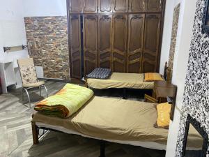 Ben ʼAknoûnRue Mohamed khoudi El Biar的一间带两张床和椅子的房间