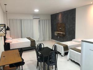伦索伊斯Lençóis Prime Apartments的一间设有两张床和一张桌子及椅子的房间