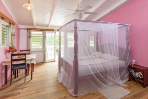 Crochu卡比尔海洋小屋宾馆的一间卧室配有一张带蚊帐的床