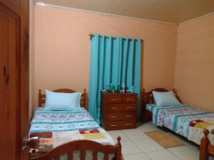 ArimaTessa's Inn的配有蓝色窗帘的客房内的两张床