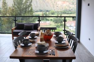 瓦努科Terraza house的一张木桌,上面有杯子和一碗食物