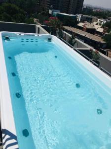 圣地亚哥Departamento Barrio Italia的一座大型蓝色游泳池,位于一座建筑的顶部