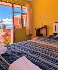 奥科苏尤Amantani sol Andino的一间卧室设有一张床和一个美景窗户。
