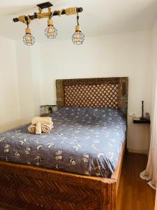 格拉纳达Apartamento 10 minutos de centro de Granada的一间卧室配有一张带木制床头板的床