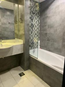 迪拜Ramble Stay Hostel Burj Khalifa view的带浴缸、水槽和淋浴的浴室