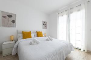 科斯塔特吉塞Casa Moure的白色卧室配有一张白色大床和黄色枕头