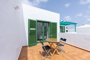 科斯塔特吉塞Casa Moure的阳台配有桌椅和绿色百叶窗