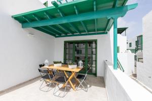 科斯塔特吉塞Casa Moure的天井上的绿色凉棚,配有木桌和椅子