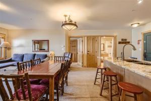 铜山Copper Springs 320 condo的厨房以及带木桌和椅子的客厅。