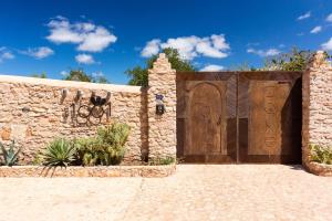 El ArbaRiad des 1001 Fleurs的石墙中的木门,有车道