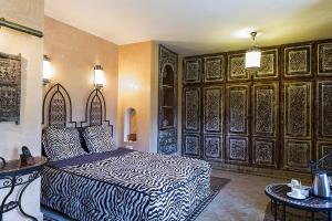 El ArbaRiad des 1001 Fleurs的卧室配有一张床铺,位于带木墙的房间内