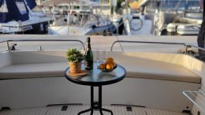 巴塞罗那Cosy and Homey Houseboat Castelldefels的船上的桌子,上面放着一瓶葡萄酒和水果
