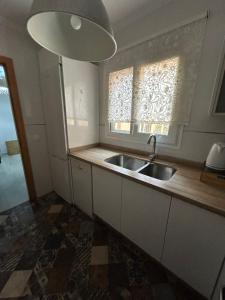 托雷德尔马尔Apartamento Ve&Va的厨房设有水槽和窗户。