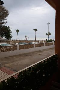 托雷德尔马尔Apartamento Ve&Va的停车场内有棕榈树的白色围栏