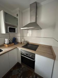 托雷德尔马尔Apartamento Ve&Va的厨房配有水槽和炉灶 顶部烤箱