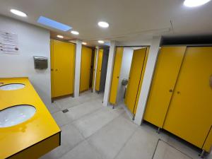 巴塞罗那Cosy and Homey Houseboat Castelldefels的浴室设有两个水槽和黄色的摊位