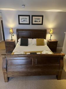 HatherleighThe George Inn的一间卧室配有一张带两盏灯的大木床。