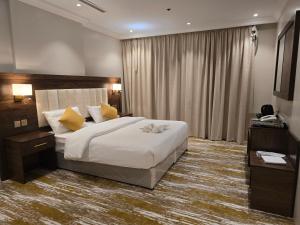 吉达سحابة الأحلام - Dream Cloud Hotel的卧室配有一张带黄色枕头的大型白色床。