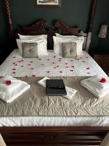 HatherleighThe George Inn的一张红玫瑰床和一台笔记本电脑