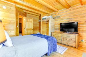 杰克逊Cozy Mountain Condo Across From Snow King Ski Mtn!的一间卧室配有一张床和一台平面电视