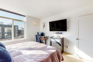 西雅图Urban Oasis的一间卧室配有一张床和一台平面电视