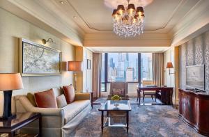 上海上海外滩华尔道夫酒店的客厅配有沙发和带钢琴的桌子。