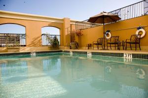 圣安娜Hotel Zessa Santa Ana, a DoubleTree by Hilton的一个带椅子和遮阳伞的大型游泳池