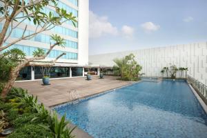 雅加达DoubleTree by Hilton Jakarta Kemayoran的大楼前的游泳池