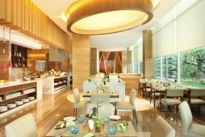 雅加达DoubleTree by Hilton Jakarta Kemayoran的一间带桌椅的餐厅和一间厨房