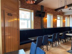 利物浦The Royal Crest的一间设有蓝色椅子的用餐室和一间酒吧