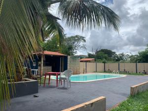 ParanaíbaHotel Pousada Lagoa Azul的一个带桌椅的游泳池以及棕榈树