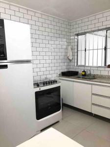 圣保罗Encontro Open House的白色的厨房配有炉灶和冰箱。