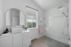 汤斯维尔Charming 3-Bedroom Retreat的带淋浴和盥洗盆的白色浴室