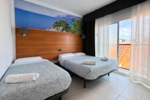 罗列特海岸Hotel Maremagnum的酒店客房设有两张床和大窗户。