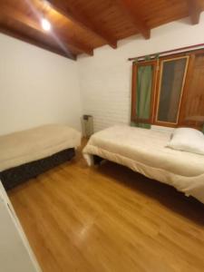 圣卡洛斯-德巴里洛切Casa Arrayan - Entorno único 20 metros del lago的客房设有两张床,铺有木地板。