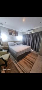 阿克拉The Signature Hotel Apartment Accra Ghana的一间卧室设有一张大床和一个窗户。